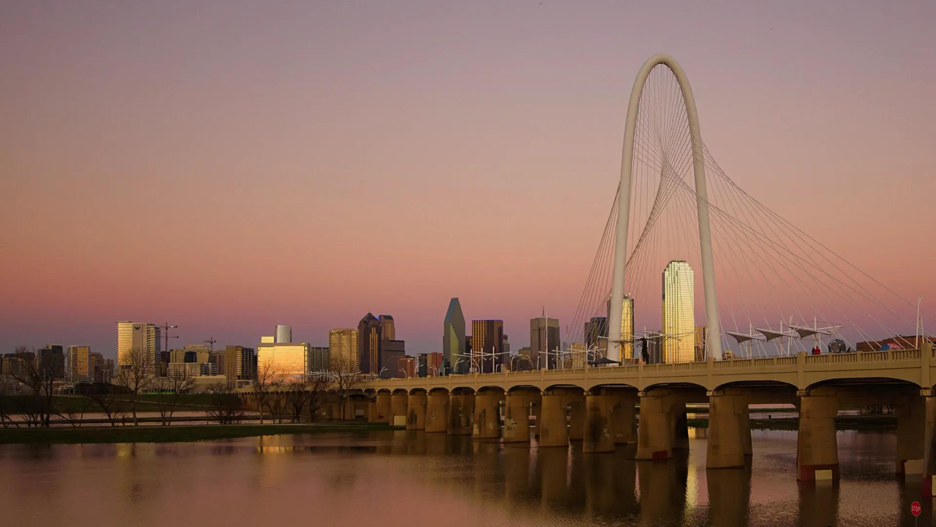 a bridge over a body of water with a city in the background
